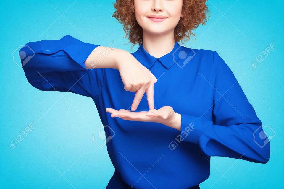 Vista parcial del profesor positivo que muestra gesto que significa estar de pie en lenguaje de señas aislado en azul