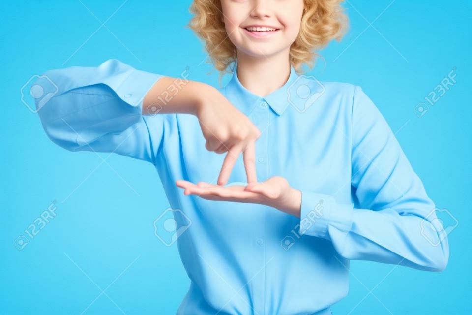 Vista parziale dell'insegnante positivo che mostra il significato del gesto stare sul linguaggio dei segni isolato sul blu