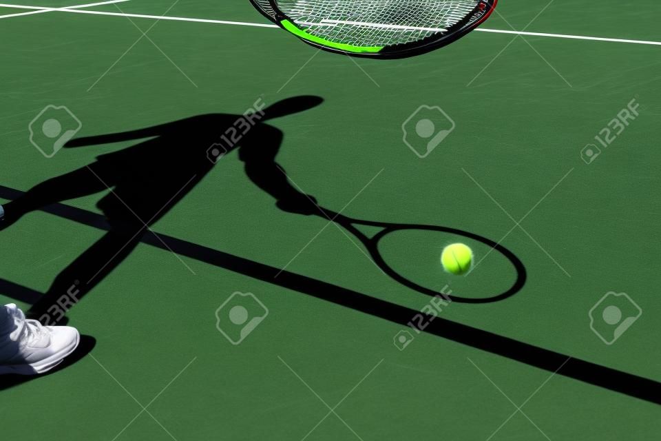 sombra de un jugador de tenis en la acción en una pista de tenis (imagen conceptual con una pelota de tenis se extiende en la cancha y la sombra del jugador de posición de una manera que parece estar jugando)