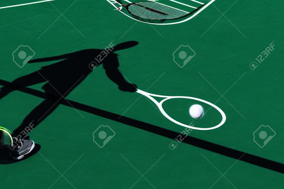 sombra de un jugador de tenis en la acción en una pista de tenis (imagen conceptual con una pelota de tenis se extiende en la cancha y la sombra del jugador de posición de una manera que parece estar jugando)