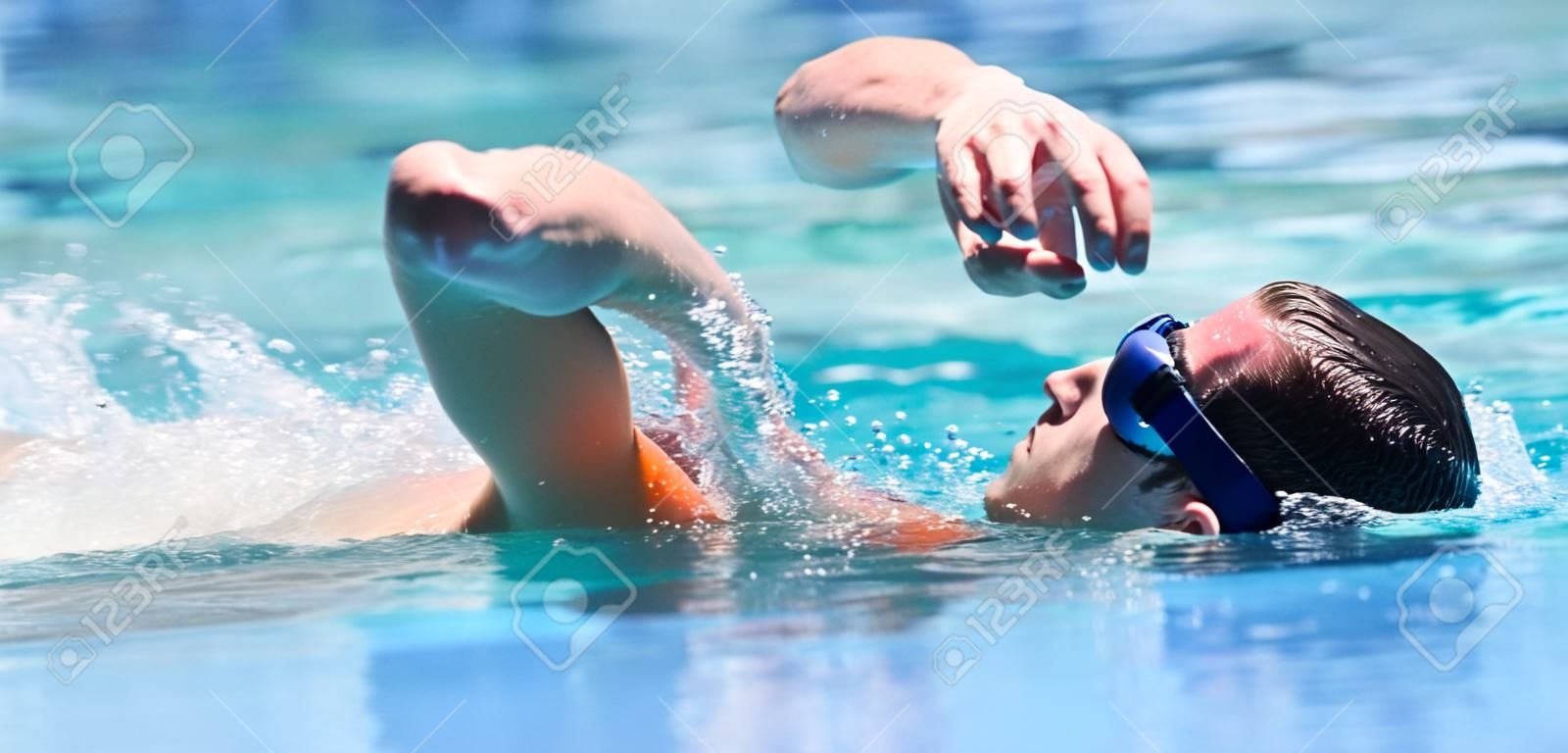 Młody człowiek pływanie przednią indeksowanie w basenie