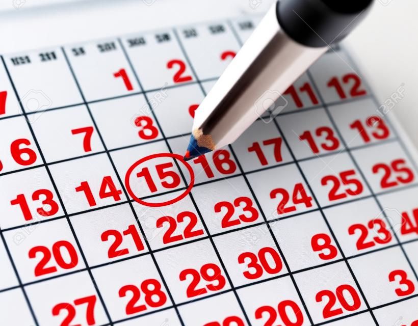 Establecer una fecha importante en un calendario con un lápiz rojo marcado un día del mes que representa la organización de tiempo y programación.