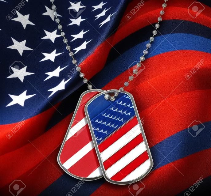 Dog Tags with a proud American Flag with blank metal and beaded necklace on red  white and blue symbol of the American military identification of soldiers for emergency medical attention for wounded and fallen heroes.