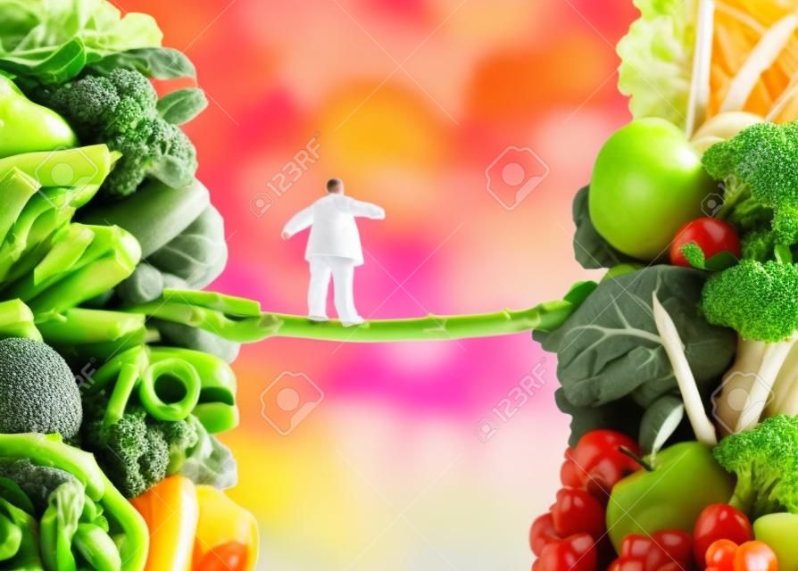 Diet change healthy lifestyle concept and having the courage to accept the challenge of losing weight and fighting obesity and diabetes as an overweight person walking on a highwire asparagus from fatty food towards vegetables and fruit.