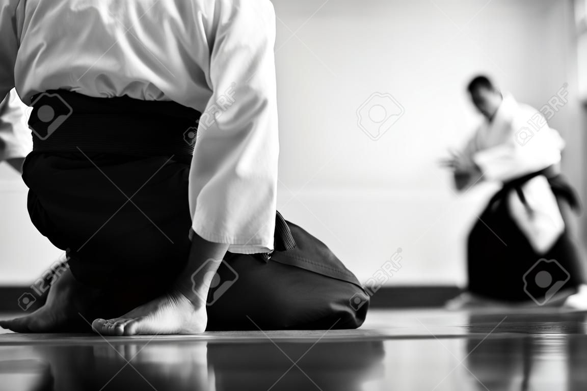 Entrenamiento de Aikido. Imagen en blanco y negro. El maestro muestra recepción. Forma tradicional de vestimenta en Aikido.