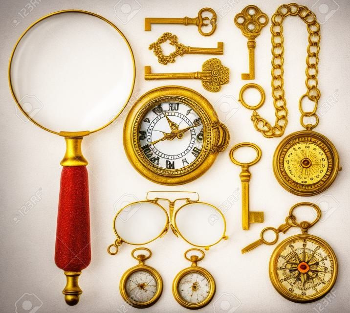 collection of golden vintage accessories, jewelry and objects. antique keys, clock, loupe, compass, glasses isolated on white background