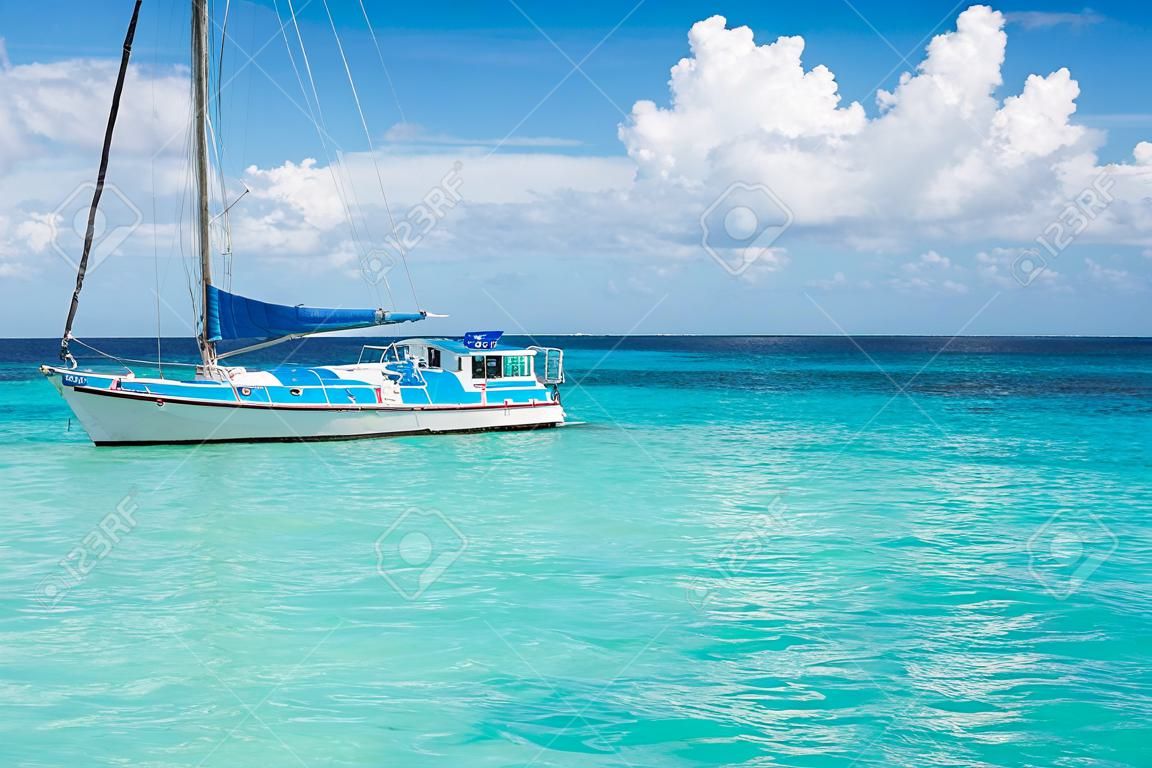 Łódź w środku Morza Karaibskiego otoczony niebieskim Skye i chmury