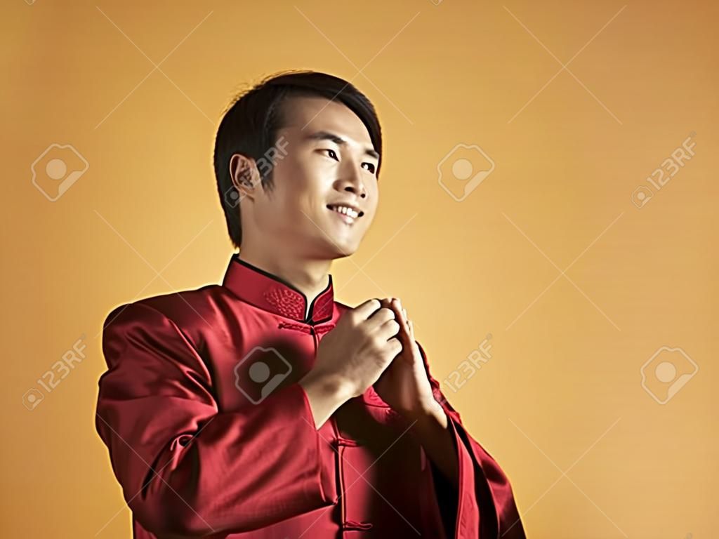 man in traditional costume greeting for chinese new year