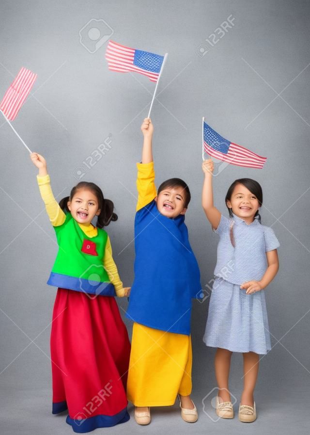 Lenght completo de três crianças que prendem a bandeira