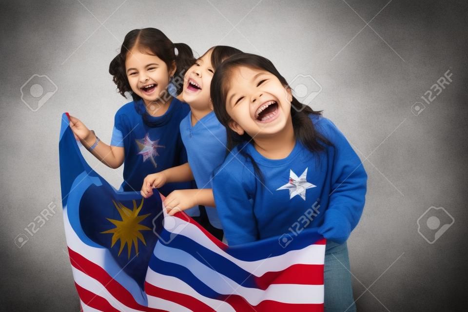 Trzy dziewczyny trzymające flagę, śmiejące się