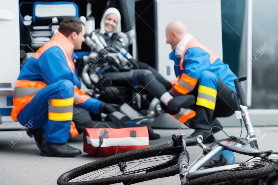Mujer en bicicleta Accidente Obtenga ayuda de emergencia paramédicos en una ambulancia