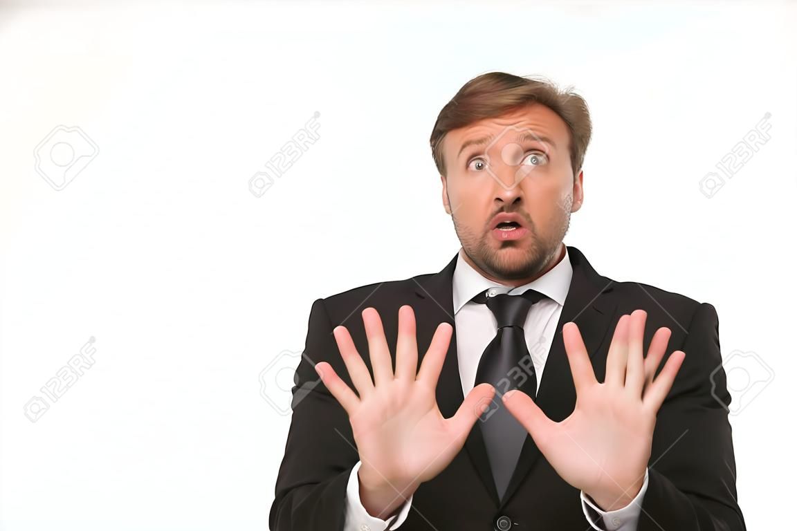 Picture of frightened businessman isolated on white background. Man in business suit showing fear with his hands.