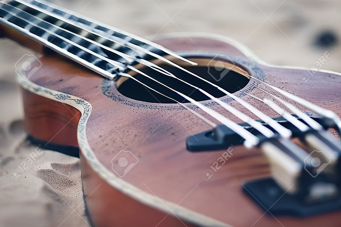 Ukulele guitar on a sand close up