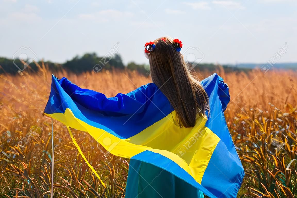 Ragazza in piedi indietro tenendo la bandiera dell'Ucraina