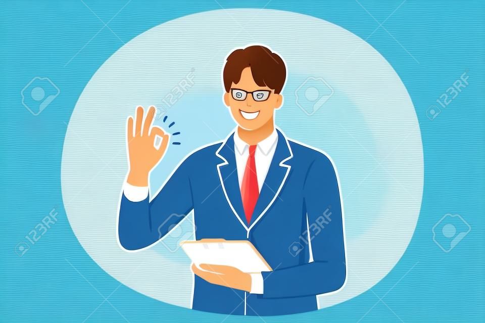 Pozytywne emocje, ok koncepcja języka znaków i gestów. młody pozytywny biznesmen postać z kreskówki stojąca z tabletem lub dokumentami w ręku i pokazująca palcami zgadza się znak sukcesu