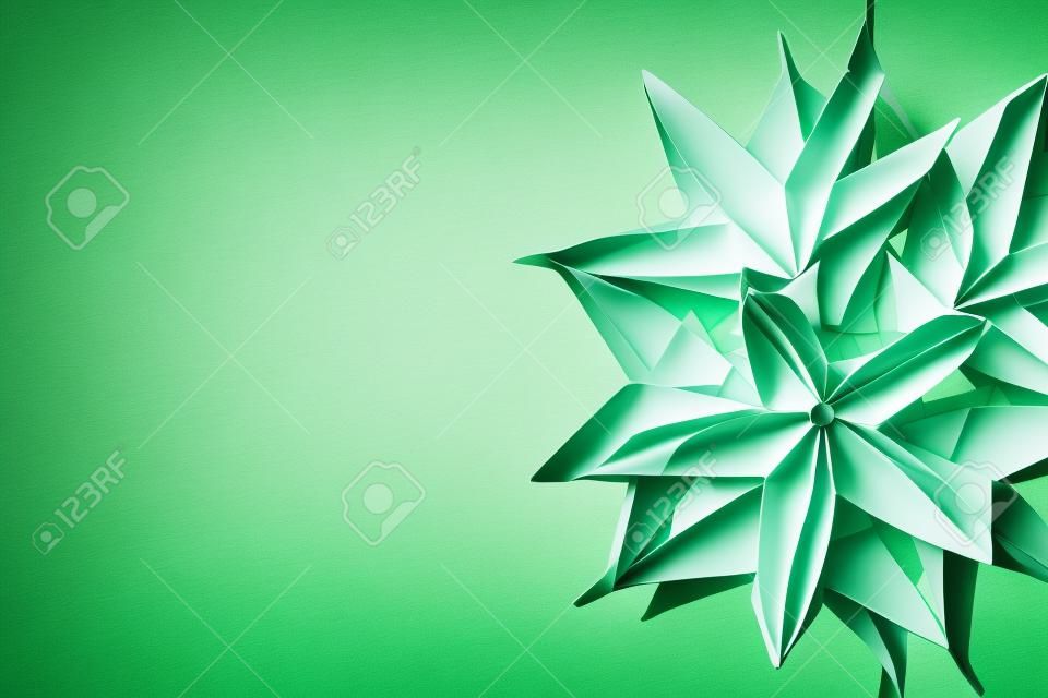 Green and white origami star flowers with copy space and selective focus
