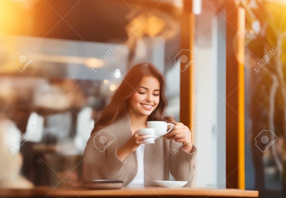 Junge Frau mit einer Tasse Kaffee im Café am Morgen