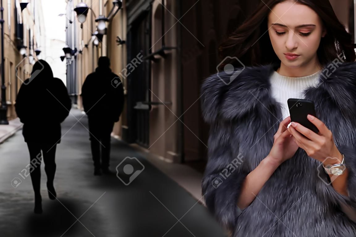 Man stalking young woman with phone in alley