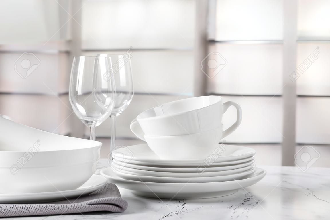 Set of clean tableware on white marble table
