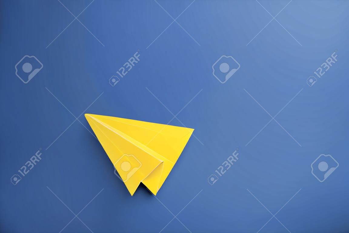 Aereo di carta giallo su sfondo blu, vista dall'alto. spazio per il testo