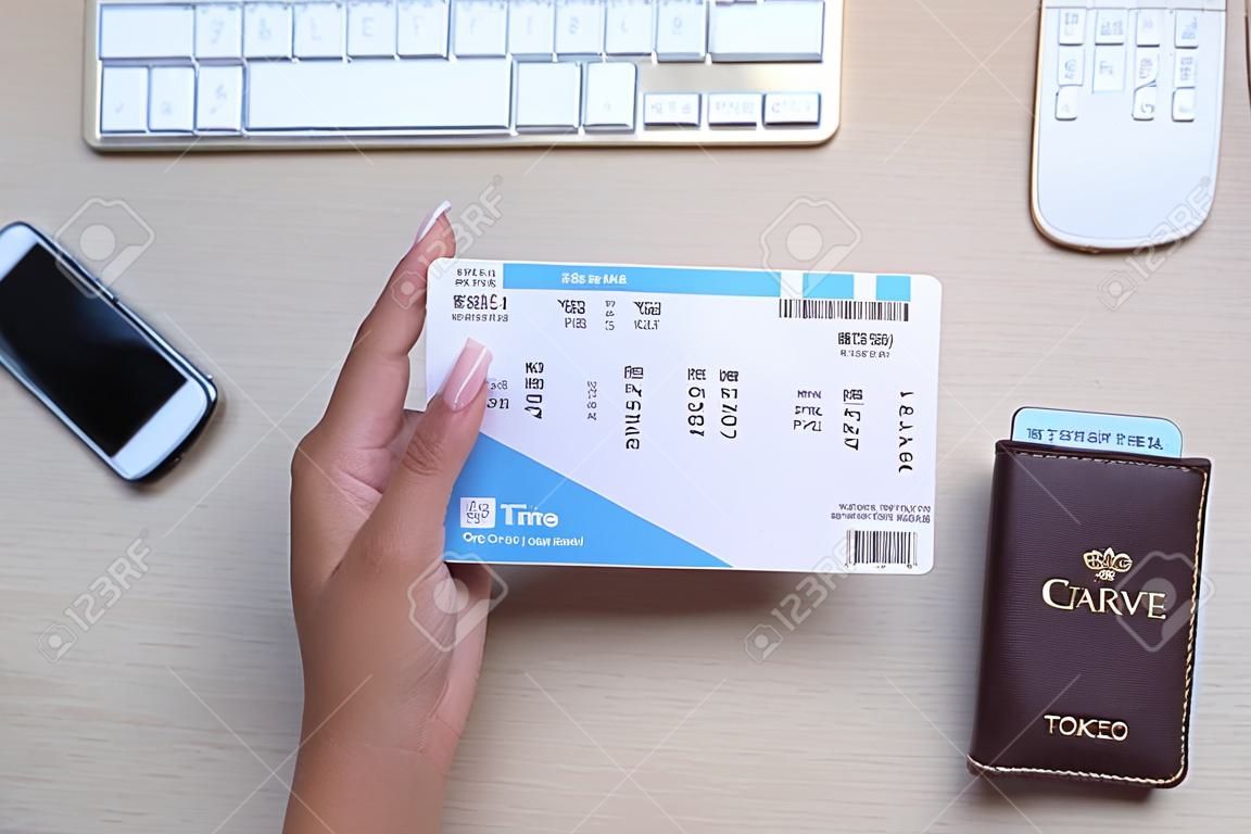 Vrouw met ticket aan tafel, top view. reisbureau concept