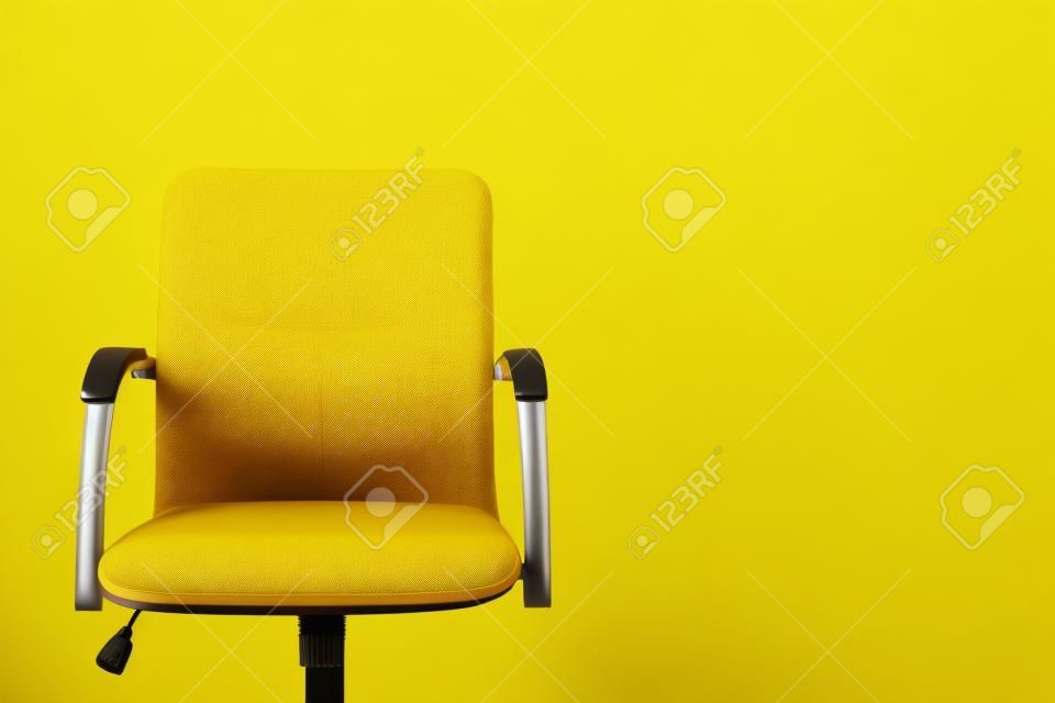 Moderner Bürostuhl auf gelbem Hintergrund. Platz für Text