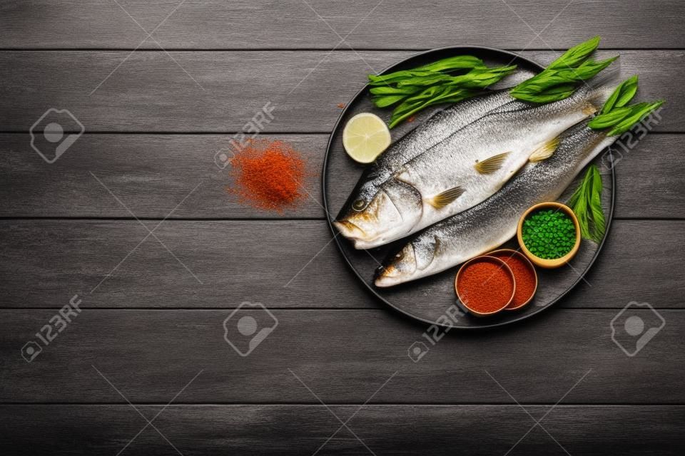 Délicieux poisson de bar aux épices sur une table en bois sombre, espace plat pour le texte