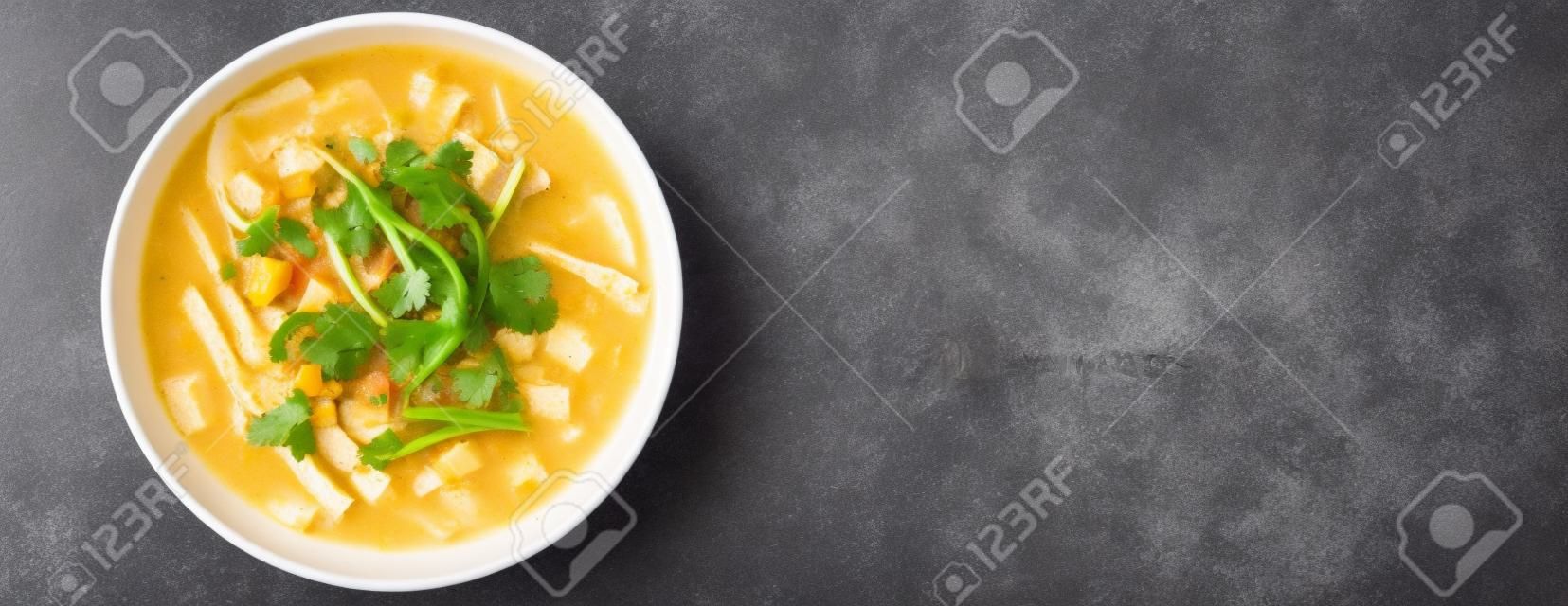 Homemade Sopa a La Minuta in a white bowl on a black surface, top view. Flat lay, overhead, from above. Space for text.