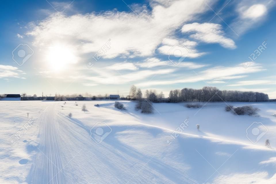 Winter landscape. Countryside. Snowy road. Sunny day. Blue sky White clouds Horizontal