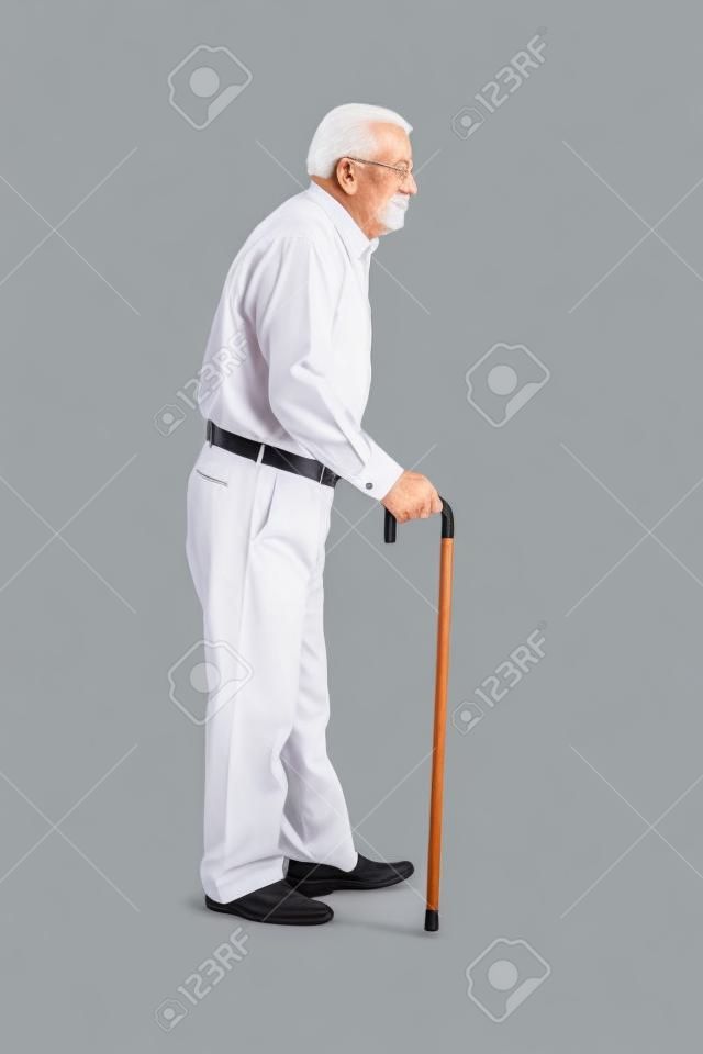 Retrato de cuerpo entero de un hombre mayor caminando con un bastón aislado en el fondo blanco