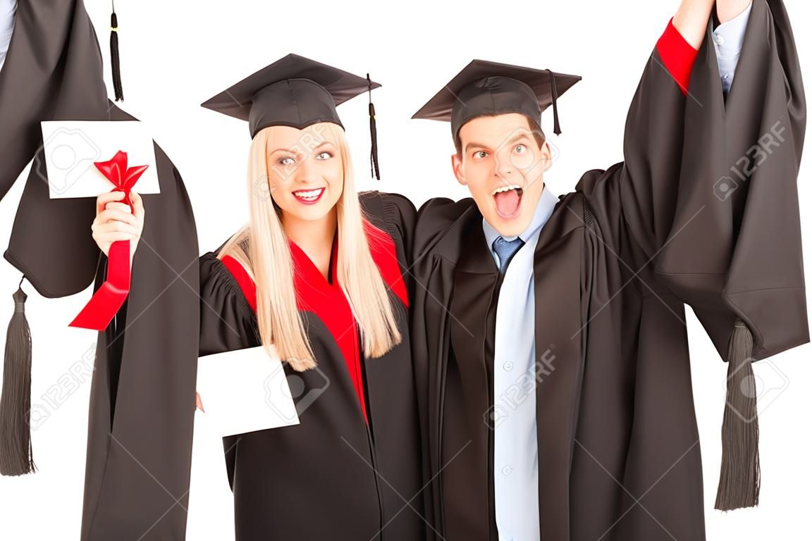Estudiante masculino y femenino que celebra su graduación aislado en fondo blanco
