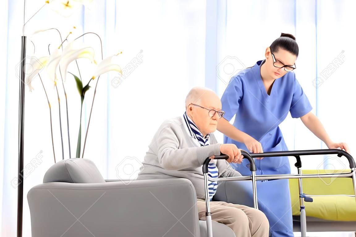 Infermiere aiutare un anziano signore di stare in una casa di cura