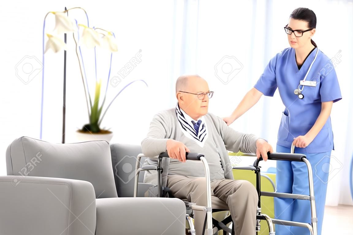 男護士幫助一位老人站起來，在養老院