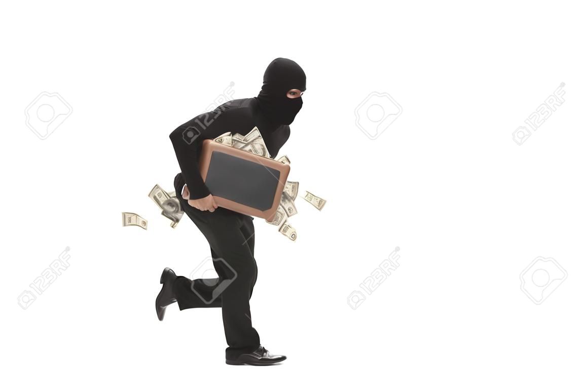 Studio shot of a male burglar with a mask on his head running with a briefcase full of money isolated on white background