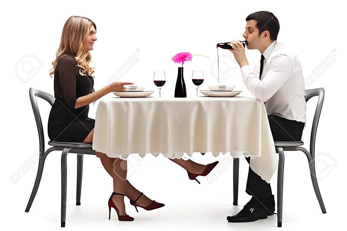 Junge Frau, die einen Mann unter den Tisch zu berühren mit ihrem Fuß auf weißem Hintergrund