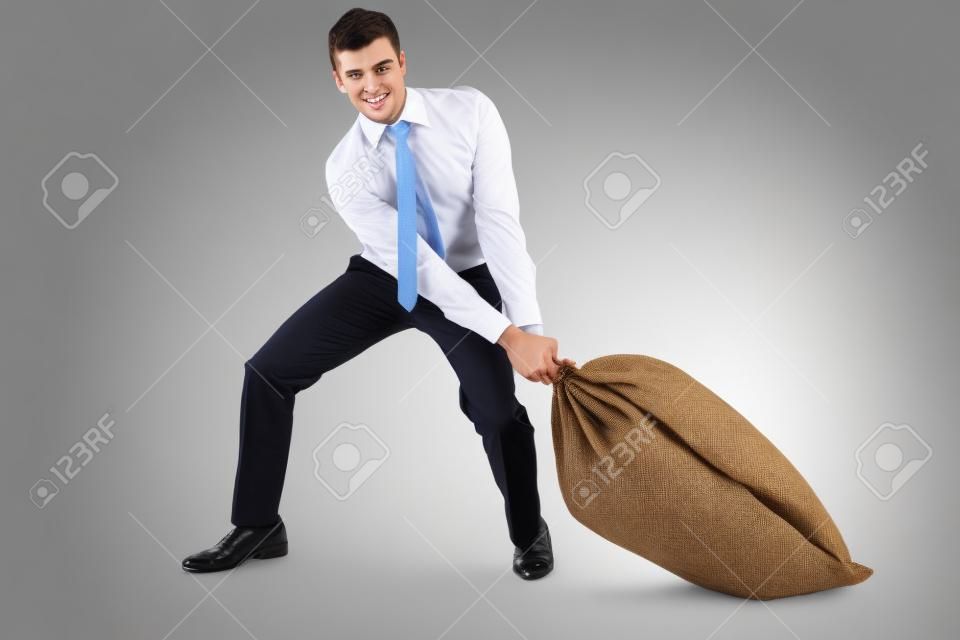 Young businessman pulling a burlap sack isolated on white background