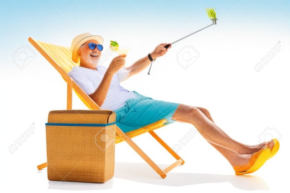 Happy älterer Touristen mit einem Cocktail sitzt in einer Sonnenliege und ein Selfie isoliert auf weißem Hintergrund