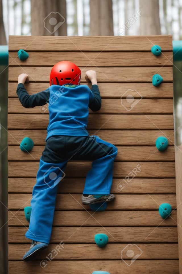 Details of an outdoors climbing girl on a climbing wall for kid