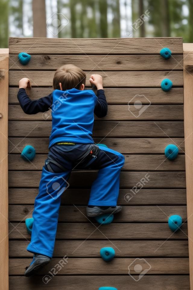 Details of an outdoors climbing girl on a climbing wall for kid