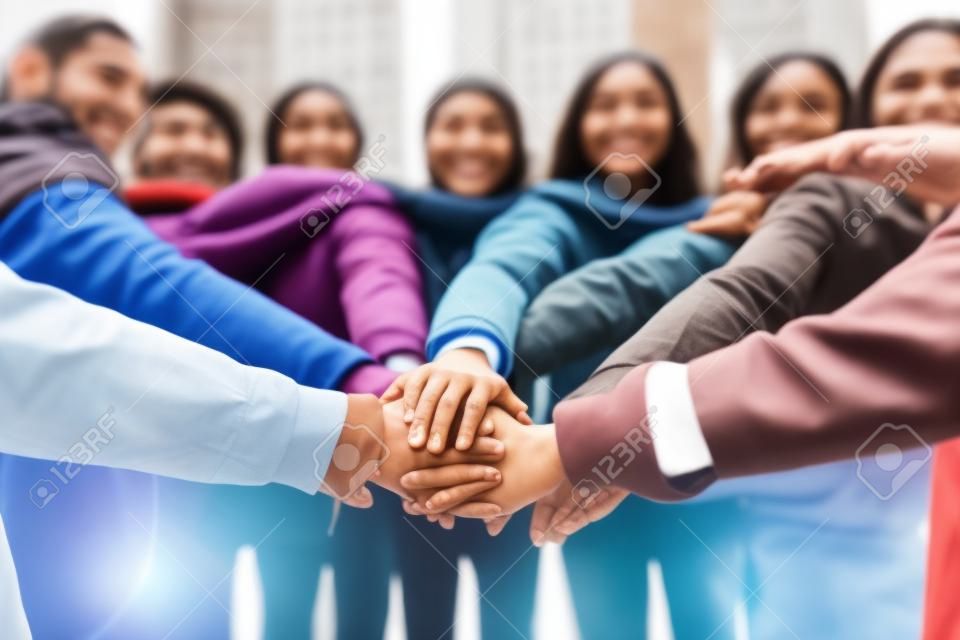 Generative AI : Multi ethnic young people team stacking hands together outside  International university students support and help each other  Friendship team building human relati