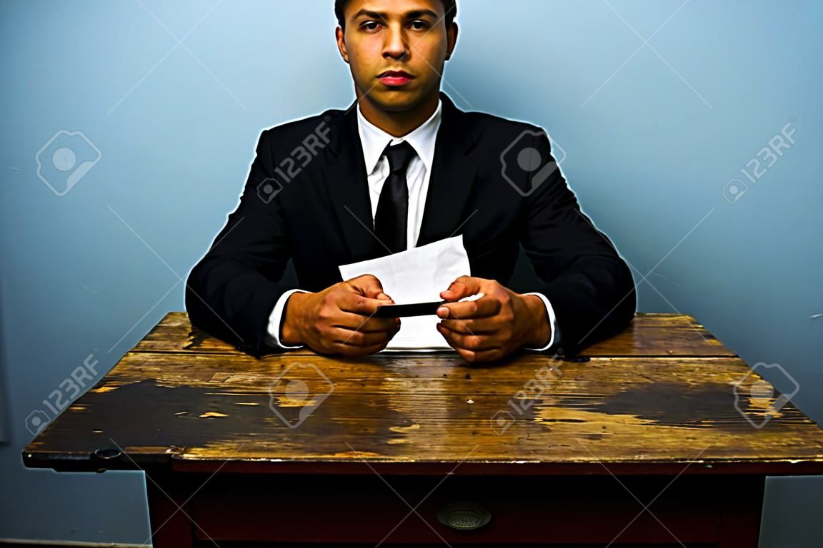 Biznesmen siedzi na starym biurku
