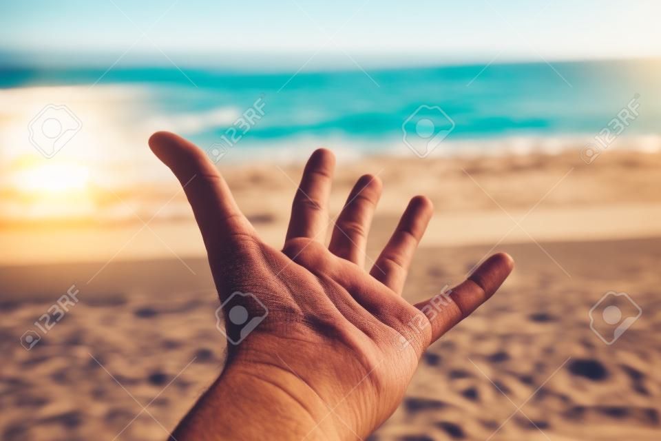 Man s hand at the beach on sunny day