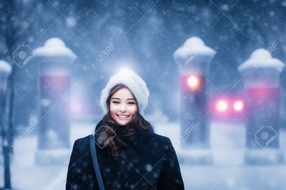 Una giovane donna sta camminando in strada in inverno