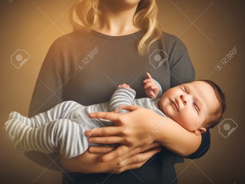 A young mother is holding her baby son