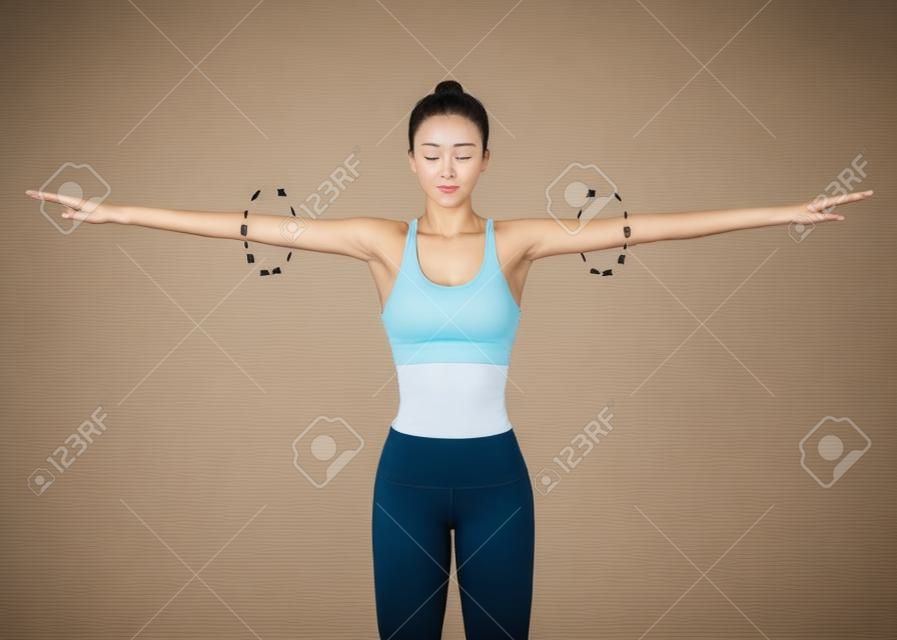 Close up of Woman doing exercise with arm circle posture for warm up. Rotation arms help to prevent injuries and prepare your body for strength training.