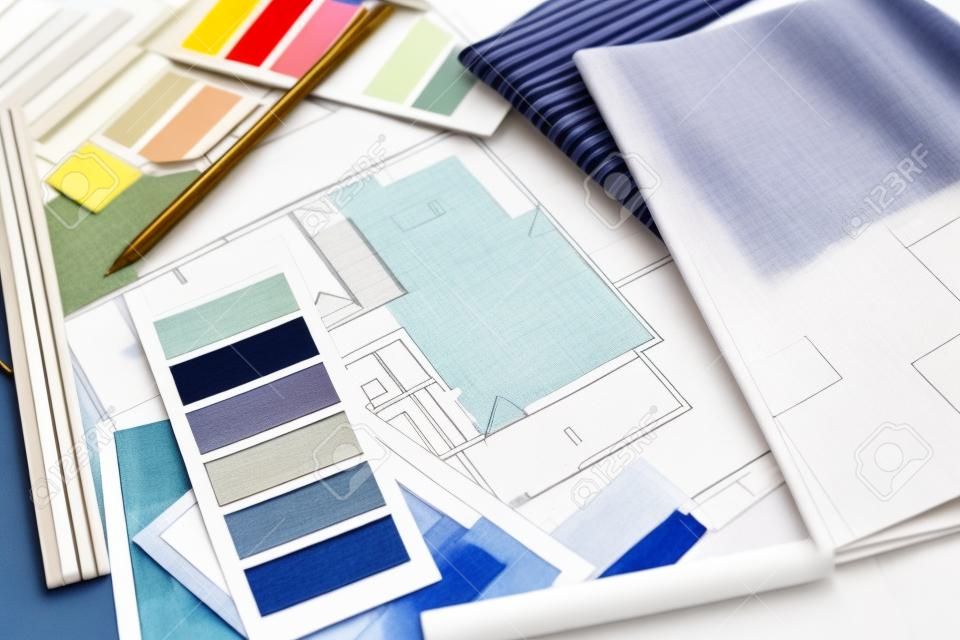室內設計師的工作表，房子的建築計劃，調色板，家具和織物樣品中的藍色。圖紙和計劃裝修房子。