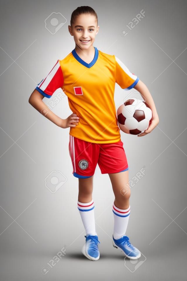 Девушка в спортивной одежды с футболом, изолированных на белом фоне
