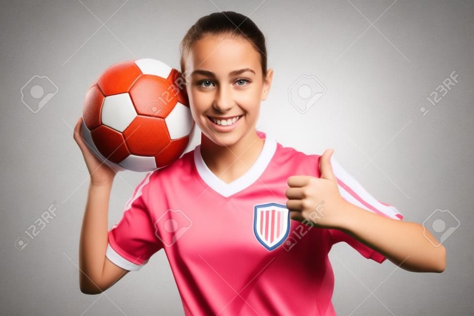 Uma garota no desgaste do esporte com futebol isolado no fundo branco