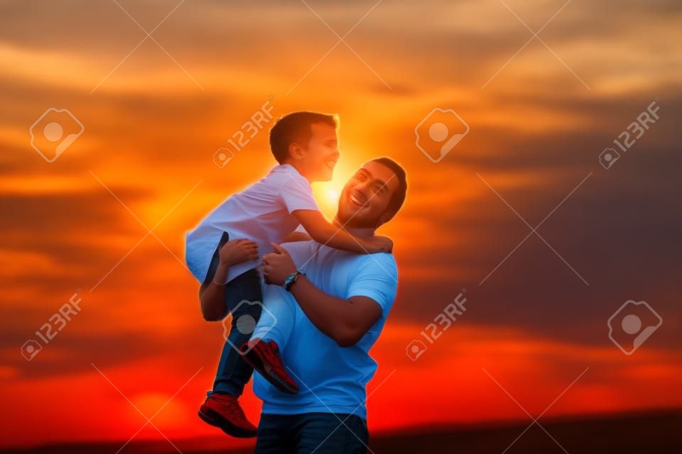 Um pai com é filho ao pôr-do-sol