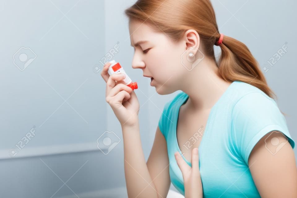 Een Astmatische die haar inhalator gebruikt vanwege ademproblemen